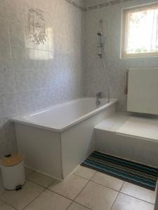a white bathroom with a tub and a toilet at Belle vue étoilée in Saint-Ouen