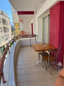 a balcony with a table and chairs on a building at Elsuarha Apartment in Pogradec