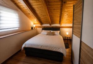 a bed in a room with a wooden ceiling at Holiday House Pulina in Punat +45 photos