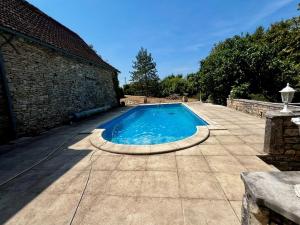 a swimming pool in front of a brick building at La Maison de Renée in Sainte-Eulalie-dʼAns +16 photos