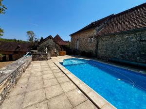 a swimming pool in the yard of a house at La Maison de Renée in Sainte-Eulalie-dʼAns