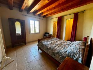 a bedroom with a bed and a wooden ceiling at La Maison de Renée in Sainte-Eulalie-dʼAns