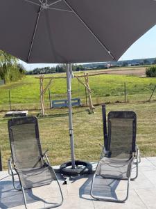 two chairs sitting under an umbrella on a patio at Agmara in Zamość