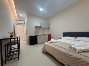 a bedroom with a bed and a desk and a kitchen at La Vista Suite and Rooms in Ladispoli