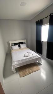 a bedroom with a bed with a window and a rug at Casa da Gi em Piranhas in Piranhas