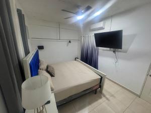 a small room with a bed and a flat screen tv at Apto Próximo al Aeropuerto Gregorio Luperón in Puerto Plata