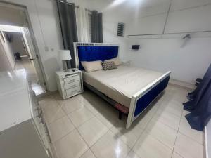 a bedroom with a bed with a blue headboard at Apto Próximo al Aeropuerto Gregorio Luperón in Puerto Plata