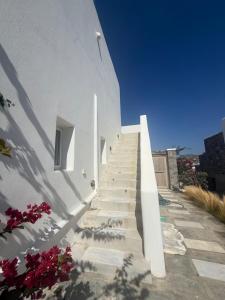 a staircase leading up to a white building with flowers at Klouvas apartment in Klouvas
