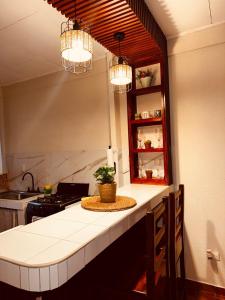 a kitchen with a counter with two lights above it at Sweet Home JACÓ in Herradura