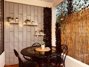 a table and chairs in a room with a wall at Sweet Home JACÓ in Herradura