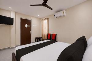 a bedroom with a bed and a ceiling fan at Hotel O Saikrishna Inn in Rājahmundry