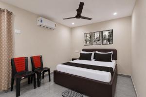 a bedroom with a bed and two chairs at Hotel O Saikrishna Inn in Rājahmundry +26 photos