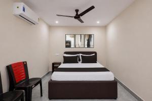 a bedroom with a bed and a ceiling fan at Hotel O Saikrishna Inn in Rājahmundry