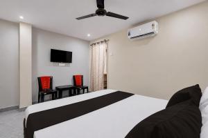 a bedroom with a bed and a flat screen tv at Hotel O Saikrishna Inn in Rājahmundry