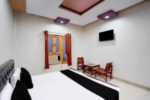 a bedroom with a bed and a table and a window at Hotel O Jhandi Palace in Lakhīmpur