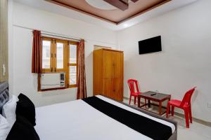 a bedroom with a bed and a table and chairs at Hotel O Jhandi Palace in Lakhīmpur