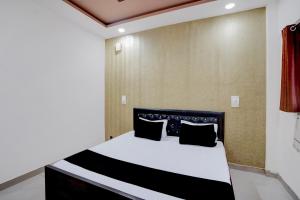 a bedroom with a bed with black and white at Hotel O Jhandi Palace in Lakhīmpur