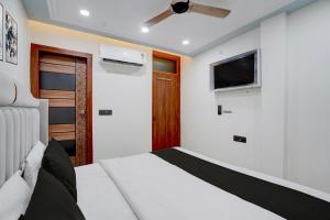 a bedroom with a bed and a flat screen tv at Hotel O Bay Inn in New Delhi