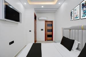 a bedroom with a bed and a flat screen tv at Hotel O Bay Inn in New Delhi