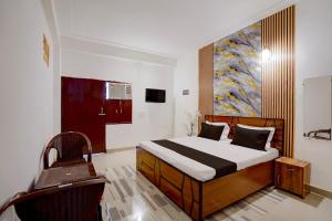a bedroom with a bed and a painting on the wall at Hotel O Moonlight Residency in Noida