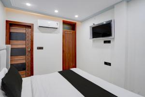 a bedroom with a bed and a flat screen tv at Hotel O Bay Inn in New Delhi +25 photos