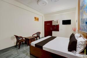 a bedroom with a bed and a table and chairs at Hotel O Moonlight Residency in Noida