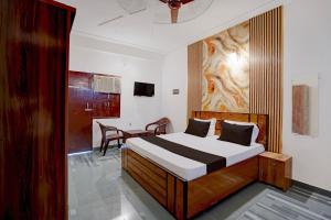a bedroom with a bed and a table in a room at Hotel O Moonlight Residency in Noida
