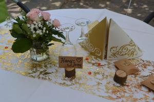 a table with a vase of flowers and wine glasses at Gasthaus Korfu in Edenkoben