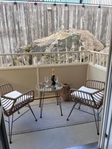 a balcony with a glass table and two chairs at Fjallbacka, Modern nyproducerad lägenhet med egen parkering och laddning in Fjällbacka