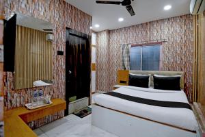 a bedroom with a bed and a brick wall at Hotel O Kolkata Park Inn in Kolkata +65 photos