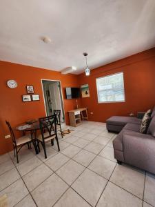 a living room with a couch and a table at Coral Apt Tropical Apartments Tobago in Scarborough