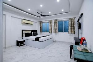a bedroom with a bed and a couch and windows at Hotel O Kolkata Park Inn in Kolkata