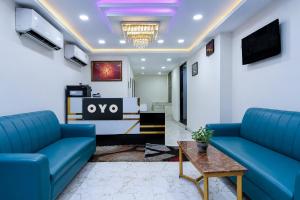 a living room with blue couches and a table at Hotel O Kolkata Park Inn in Kolkata