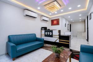 a living room with a blue couch and a table at Hotel O Kolkata Park Inn in Kolkata