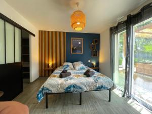 a bedroom with a bed with a blue wall at Villa de charme 4 étoiles avec piscine privée et clim 8 pers près du lac de Parentis in Parentis-en-Born +30 photos