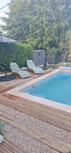 a swimming pool with lounge chairs next to at Le Vaugerin in Bléré