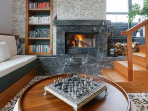 a living room with a fireplace and a chess board at Hunza Longevity Resort in Eskiömerler