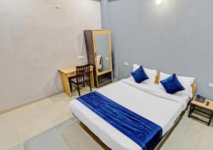 a bedroom with a large bed with blue pillows at Hotel Avira Inn-Opp Lucknow HighCourt in Lucknow