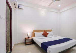 a bedroom with a bed and a table with a lamp at Hotel Avira Inn-Opp Lucknow HighCourt in Lucknow