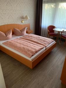 a bedroom with a large bed and a table at Pension Panorama in Hitzacker