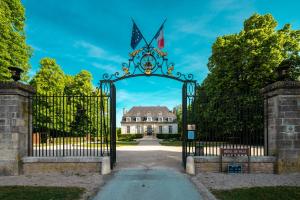 a gate to a mansion with a house in the background at Superbe Loft proche Troyes & Parking facile in Arcis-sur-Aube
