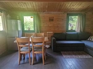 a living room with a couch and a table and chairs at Osīšu Priežu māja in Ķesterciems