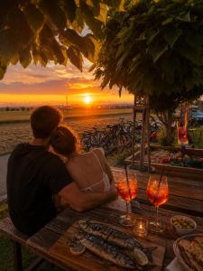 a couple sitting at a picnic table watching the sunset at Chatka U Rybičky in Babice
