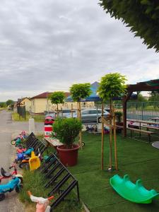 a park with benches and palm trees in the grass at Chatka U Rybičky in Babice