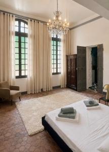 a large bedroom with a large bed and a chandelier at L'écrin de la Chartreuse in Villeneuve-lès-Avignon