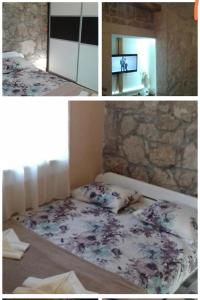a bedroom with a bed and a stone wall at Apartment Nada in Rogoznica