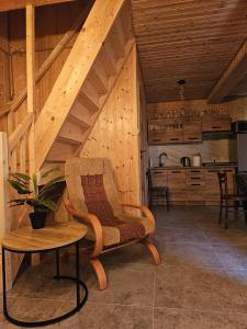 a room with a chair and a table and a kitchen at Przystań Vianneya in Giebułtów