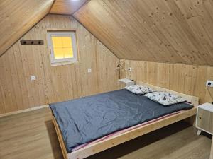 a bedroom with a bed in a wooden cabin at Przystań Vianneya in Giebułtów