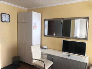 a room with a desk with a monitor and a chair at Campsite Jelgava in Jelgava