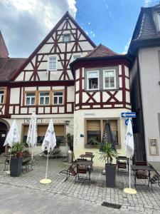 a building with tables and umbrellas in front of it at Sierra Ferienwohnung in Marktbreit